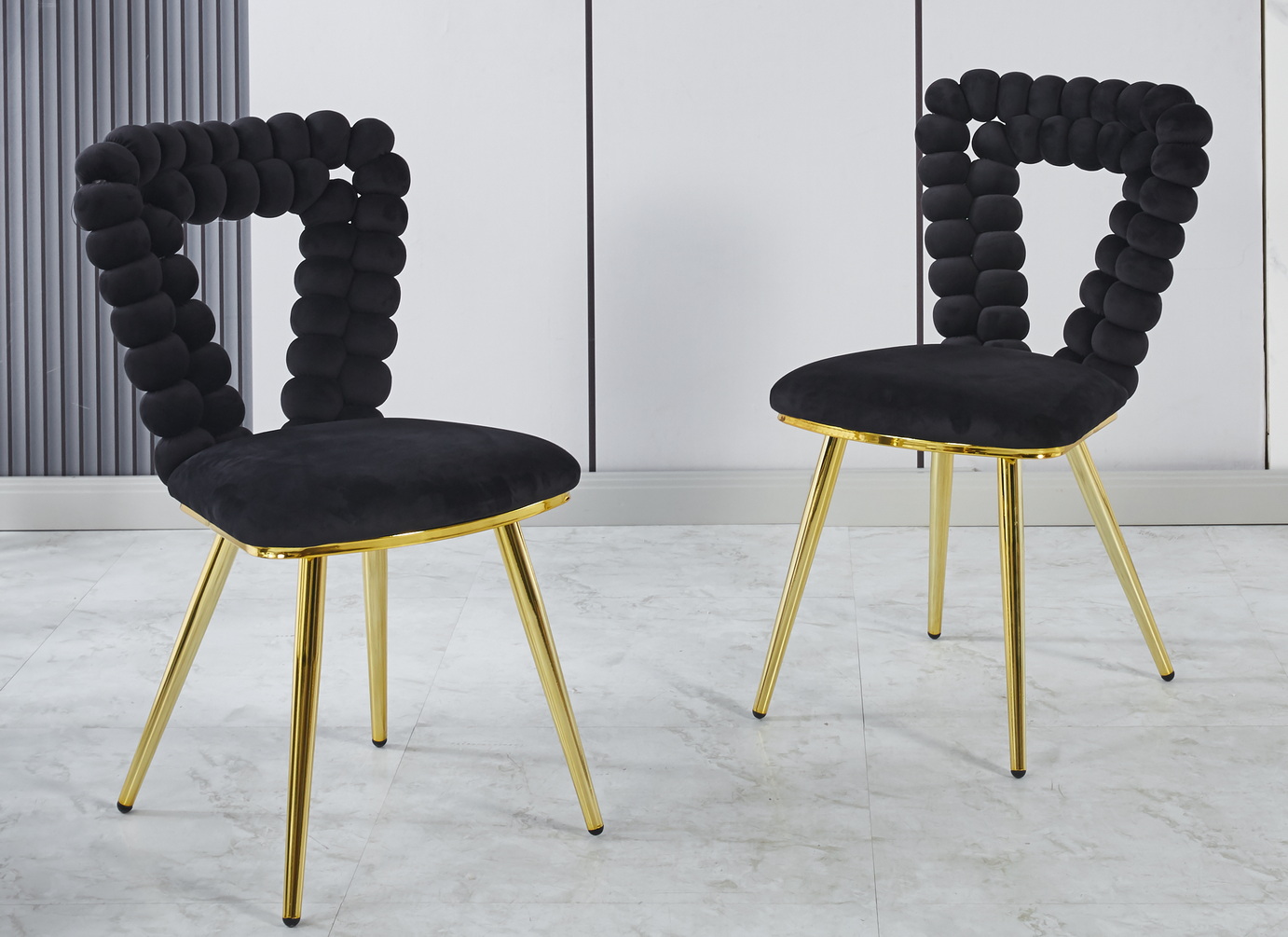 Sillas modernas (Juego de 2) con patas de hierro dorado y cojines negros suaves.